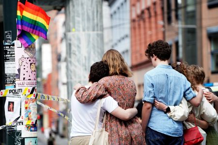 People embrace near the police line following a shooting at the London Pub, a popular gay bar and nightclub, in central Oslo, Norway June 25, 2022. Terje Pedersen/NTB/via REUTERS