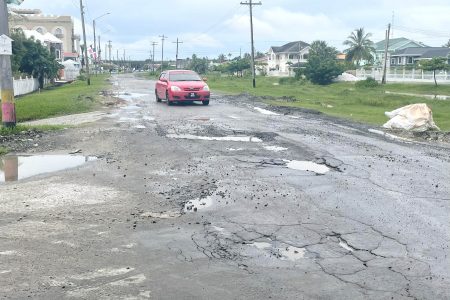 A car manoeuvring amid the potholes on the road
