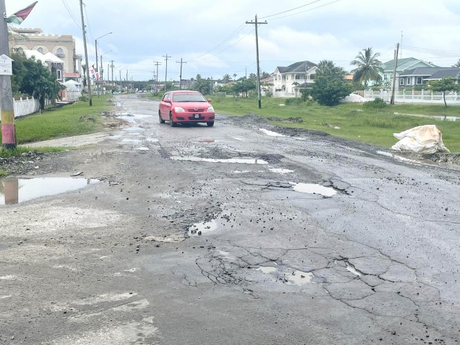 A car manoeuvring amid the potholes on the road