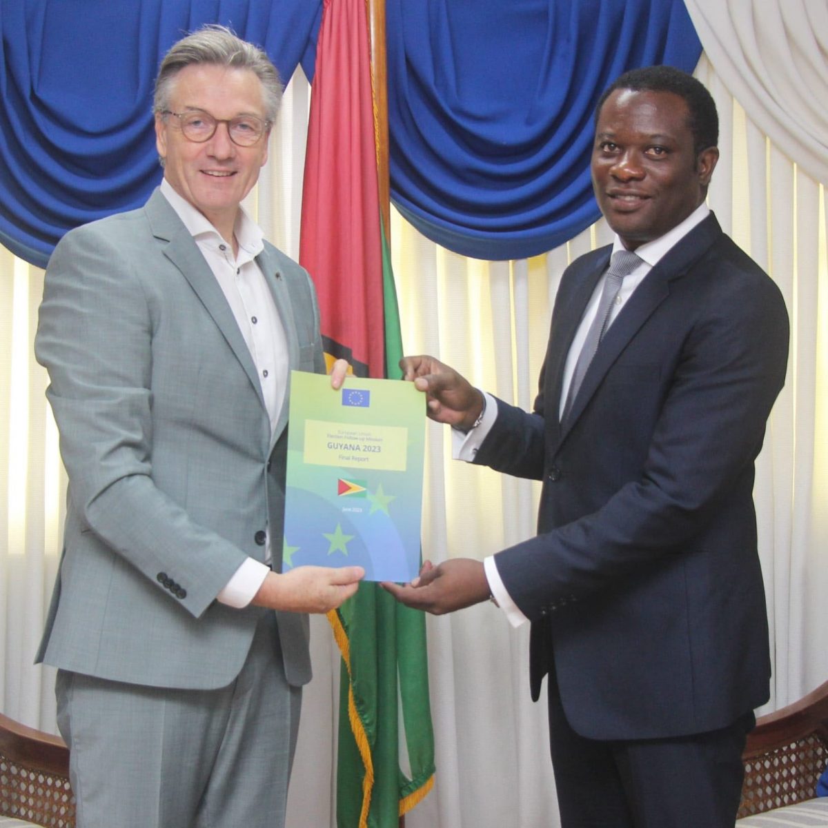 René van Nes (left), Ambassador of the European Union to Guyana handing over the report to Minister of Foreign Affairs and International Cooperation, Hugh Todd
