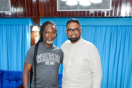 Troy Roberts (left) with President Irfaan Ali and the table (Office of the President photo)