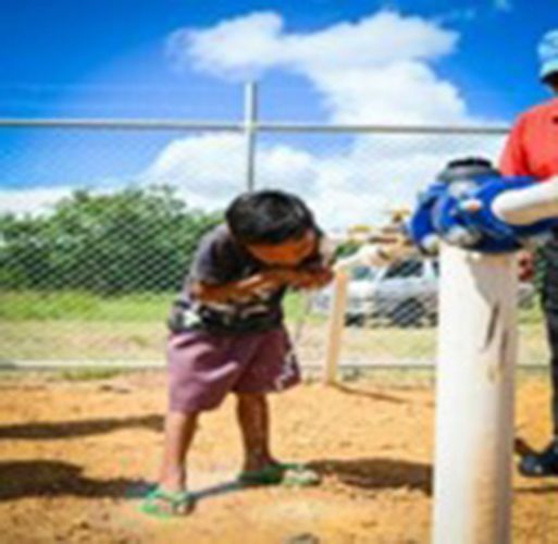 A young resident enjoys water from the new system
