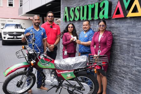 New Bike for MVP! From left: Co-Director of Kares One Guyana T10 Blast, Yusuf Ali, Sanjiv Nandlall (Assuria’s  Senior Supervisor forInformation and Communications Technology, and Marketing, Fiona Sooklall (Fire and General Insurance), Co-Director of Kares One Guyana T10 Blast, John Ramsingh and Nandanie Persaud (Marketing, Sales and Social Media Officer) at the company Church Street headquarters