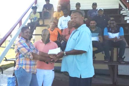 Roshel De Vieira, representative of tournament sponsor, Dior’s ‘Bits and Pieces’, presents the sponsorship cheque to BCB President Hilbert Foster in the presence of Regional Vice Chairman Rion Peters