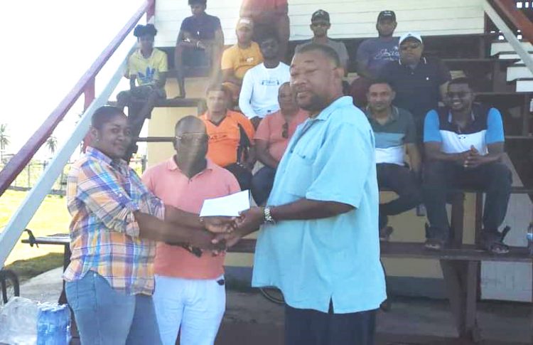 Roshel De Vieira, representative of tournament sponsor, Dior’s ‘Bits and Pieces’, presents the sponsorship cheque to BCB President Hilbert Foster in the presence of Regional Vice Chairman Rion Peters