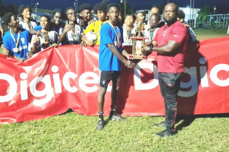 Berbice Educational Institute captain receiving the Region #6 zonal championship trophy in the presence of teammates after defeating Vryman’s Erven in the final at the Scott’s School ground 
