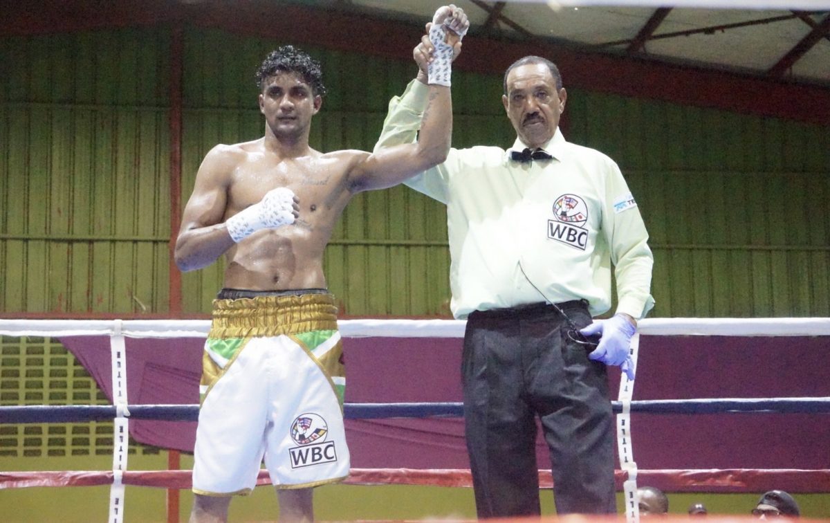 Referee, Eon Jardine raised the hand of Elton Dharry following his unanimous decision win over Colombian journeyman, Ronald Ramos on June 3 at the National Gymnasium. (Emmerson Campbell photo)