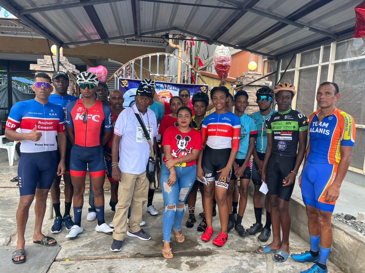 Some of the riders who competed yesterday pose for a photo with race organizer and President of the Flying Ace Cycle Club, Randolph Roberts (centre)