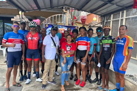 Some of the riders who competed yesterday pose for a photo with race organizer and President of the Flying Ace Cycle Club, Randolph Roberts (centre)