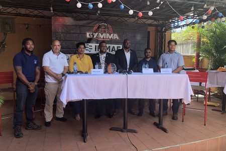 GMMAF President Gavin Singh (3rd from right) posing with team captain Corwin D’Anjou (1st from left) and teammate Christopher James following the official announcement of the Guyana team for the Pan American Championships. Also in the photo are members of Fight Central and the Pan American President Jason Holder (centre)