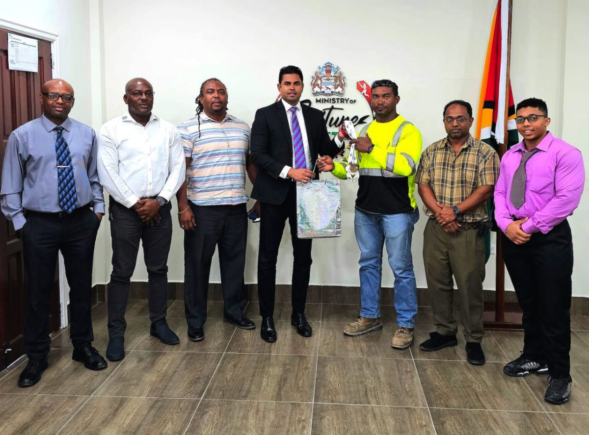 Minister Ramson receives a token from Carlos Peterson-Griffith in the presence
of from left, GAPLF Treasurer Maxwell Denney, President Franklin Wilson,
Secretary Roger Rogers, Oudit Seenarain, and Romeo Hunter.