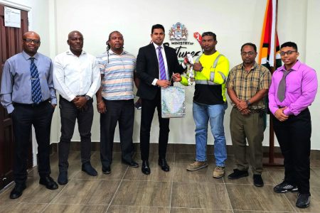 Minister Ramson receives a token from Carlos Peterson-Griffith in the presence
of from left, GAPLF Treasurer Maxwell Denney, President Franklin Wilson,
Secretary Roger Rogers, Oudit Seenarain, and Romeo Hunter.