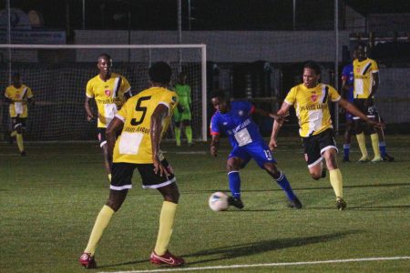 Delwyn Fraser (centre) of GPF trying to maintain possession while being challenged by a Buxton United
player in the Elite League at the National Training Centre
