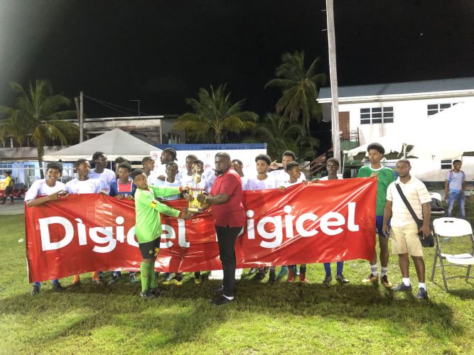 Soesdyke captain Jermin Lewis collecting the East Bank divisional championship in the presence of teammates from zone coordinator Renick Allen 