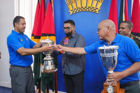 
President Irfaan Ali (second from left) yesterday met with executive members of the Guyana National Rifle Association (GNRA) at State House. During the meeting, the Head of State was presented with the West Indies Short Range Trophy that the GNRA won in May 2023, in Antigua after competing against teams from Barbados, Antigua, Jamaica and Canada. The President was also presented with a personalized team shirt.  President Ali and the GNRA also engaged in discussions about further developing the sport. (Office of the President photo)