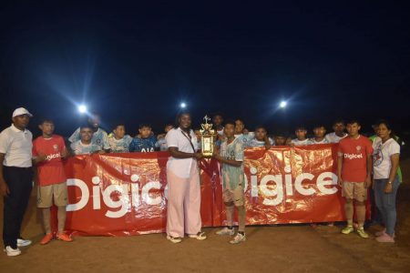 St. Ignatius captain Rayes Williams collecting the Region #9 zonal championship from Petra Organization representative Jacklyn Boodie in the presence of his teammates