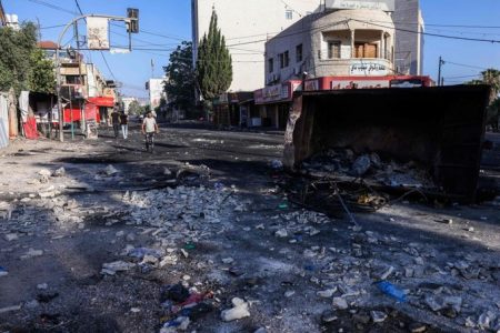 People walk along a street in the occupied West Bank city of Jenin on July 4, 2023, a day after an Israeli military operation. (AFP)