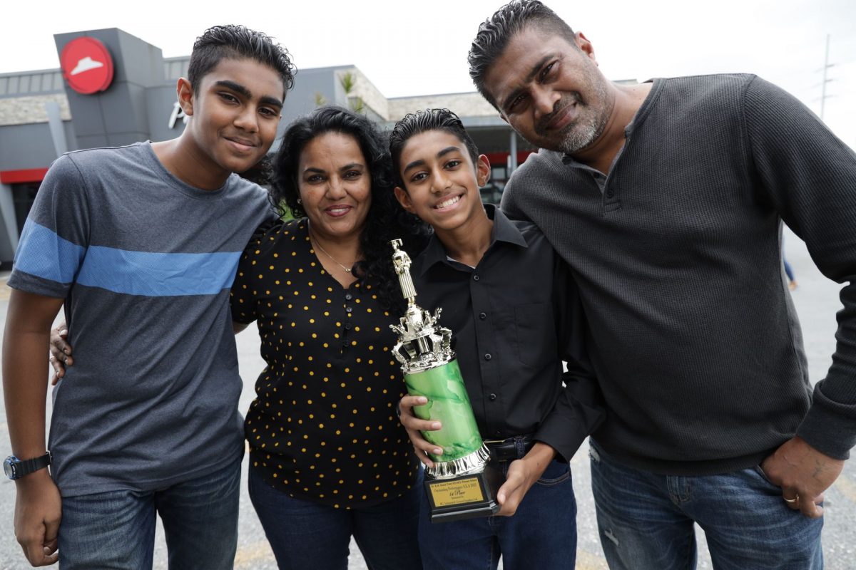 Celebrating his success after topping his school in the SEA exams, Jude Jones poses with his brother, Jake, and parents, Sunita and Jason, before heading to Gulf City for lunch yesterday.