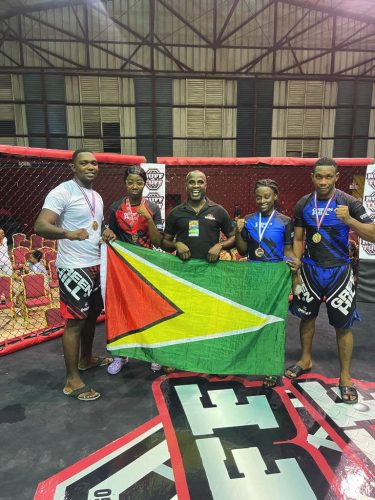 The Guyanese quartet [from left] of Carl Ramsay, Shenese Bobb, Anevia Frank and Ijaz Cave, alongside coach Troy Bobb (centre) displaying their spoils after winning four gold medals at the Ruff and Tuff Regional MMA League Invitational.