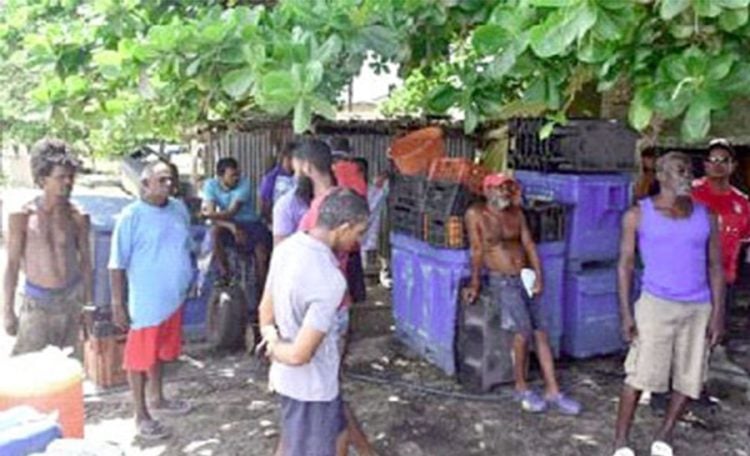 STUCK ON SHORE: Fishermen gather in Bonasse Village, Cedros, for a meeting yesterday, following Thursday’s oil spill. —Photo: TREVOR WATSON