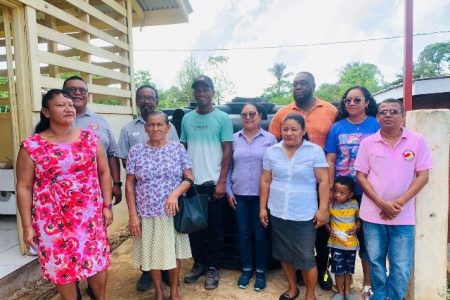 Minister of Amerindian Affairs Pauline Sukhai, regional officials and residents who benefitted from the water tanks. (DPI photo) 