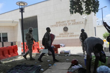 FILE PHOTO: A man carries his belongings after officers of the Haitian National Police fired tear gas to clear a camp of people escaping the threat of armed gangs, in front of the U.S. Embassy, in Port-au-Prince, Haiti July 25, 2023. REUTERS/Ralph Tedy Erol/File Photo