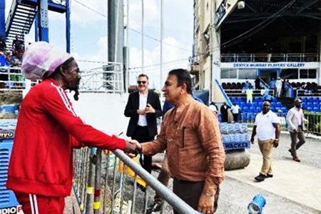 ‘SUNNY’ RETURNS: Renowned nuts man Jumbo, left, greets India cricket legend Sunil Gavaskar on Friday at the Queen’s Park Oval. At centre is Queen’s Park Cricket Club president Dr Nigel Camacho. —Photo: ROBERT TAYLOR