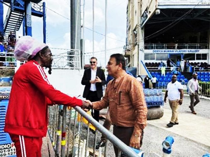 ‘SUNNY’ RETURNS: Renowned nuts man Jumbo, left, greets India cricket legend Sunil Gavaskar on Friday at the Queen’s Park Oval. At centre is Queen’s Park Cricket Club president Dr Nigel Camacho. —Photo: ROBERT TAYLOR