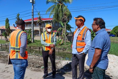 Minister of Public Works Juan Edghill (second from right) engaging contractors on the project site during his visit 