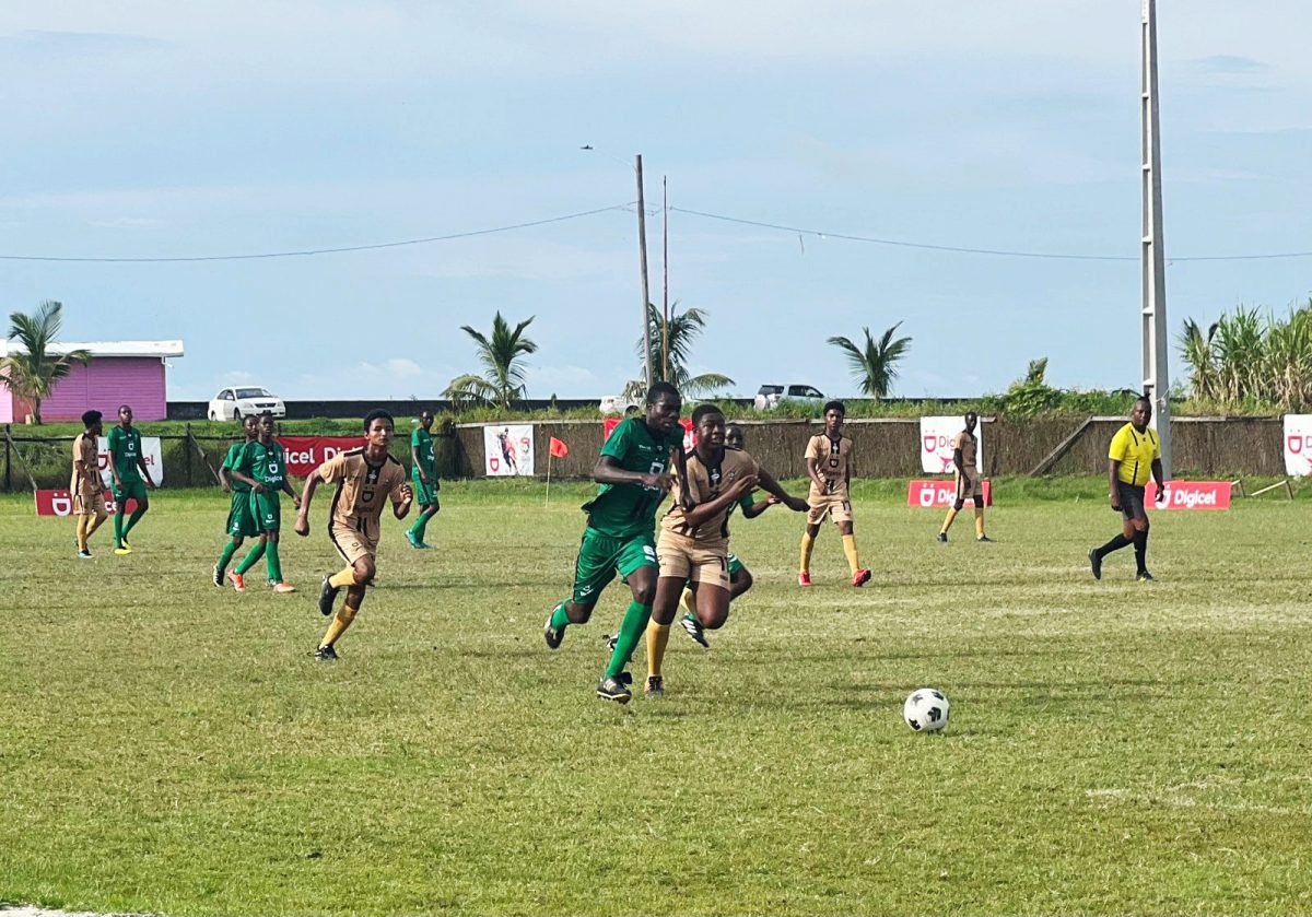 Jequan Cole (left) of Dolphin Secondary on the attack while being pursued by a Westminster defender during their Round of 16 clash in the Digicel Schools Football Championship