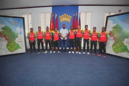 President Dr. Irfaan Ali is flanked by members of the Guyana Amazon Warriors Women’s team.