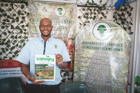 Project Officer of the Forest Products Development and Marketing Council Inc. , Paul Bassoo with a copy of Canopy magazine at the Guyana Forestry  Commission’s booth at the International Building Expo 2023, Guyana National Stadium, Providence.
