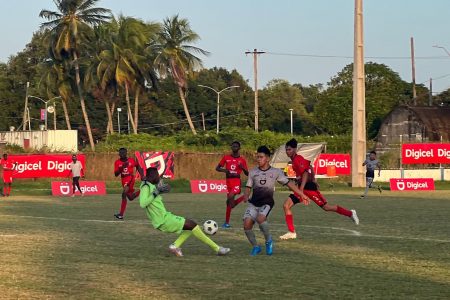 Crunching tackle! Carmel’s goalkeeper Ray Richard unleashes a crunching tackle on DC Caesar Fox’s Carrington
Isaacs during their semi-final clash at the Ministry of Education ground, Carifesta Avenue last evening.
