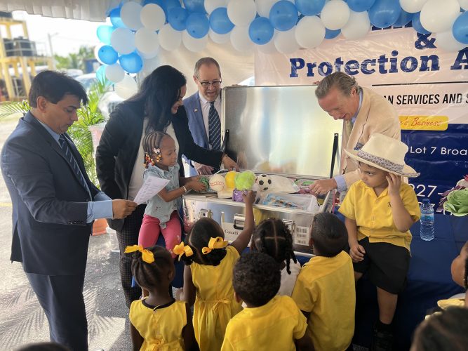 Minister of Human Services and Social Security, Dr. Vindhya Persaud; UNICEF Area Representative, Nicolas Pron; UNICEF Deputy Representative for Guyana & Suriname, Irfan Akhtar and High Commissioner of Canada to Guyana, Mark Berman along with students of the Lovable Friends and Kiskadee Daycare centres inspect an Early Childhood Development kit at the handover ceremony. (UNICEF Guyana photo)