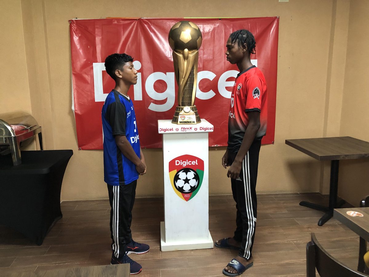 Face-off! Captain Reyes Williams of St Ignatius (left) and Skipper Shem James of Carmel posing with the coveted Digicel Schools Football Champion Lien Trophy. The duo are expected to play pivotal roles in their respective camps in their quest for the title during the final