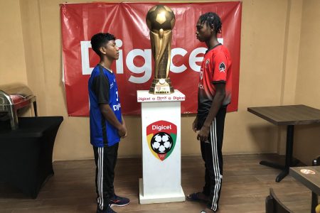 Face-off! Captain Reyes Williams of St Ignatius (left) and Skipper Shem James of Carmel posing with the coveted Digicel Schools Football Champion Lien Trophy. The duo are expected to play pivotal roles in their respective camps in their quest for the title during the final