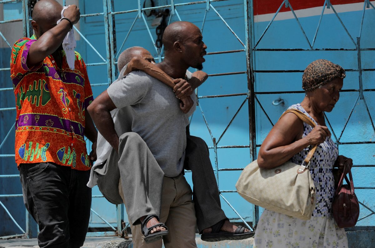 FILE PHOTO: A man carries an elderly man as they flee their neighbourhood Carrefour Feuilles after gangs took over, in Port-au-Prince, Haiti August 15, 2023. REUTERS/Ralph Tedy Erol/File Photo