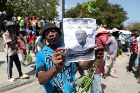 A demonstrator holds a picture of police officer Eddy Derisca, who was killed in gang violence, during a protest against insecurity in Port-au-Prince, Haiti, Monday, Aug. 7, 2023.Odelyn Joseph / AP
