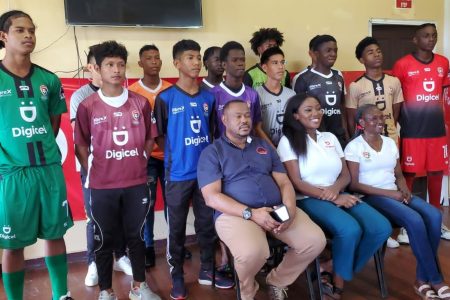 12 of the participating schools display their new team jerseys which are part of the complete team kits that were presented by the Petra Organization and Digicel. Also in the photo [sitting from left] are Petra Organization Co-Director ,Troy Mendonca, Gabriella Chapman, Communications Director of Digicel, and National Coordinator Lavern Fraser-Thomas
