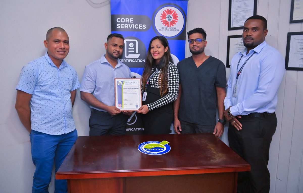 Laboratory Director of Universal Health Care Laboratory, Dr. Ravi Persaud (second from left) receiving the GNBS Certificate from GNBS Technical Officer, Rosmarie Liliah. (GNBS photo)

