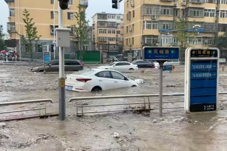Cars are partially submerged as water gushes on a flooded street, after Typhoon Doksuri made landfall and brought heavy rainfall, at the Mentougou district, in Beijing, China July 31, 2023, in this still image obtained from social media video. Video obtained by Reuters/via REUTERS 