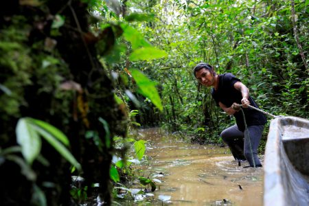 Moi Guiquita of the indigenous Waorani people, whose territory is the subject of a referendum vote that may ban oil production in their region, pulls a boat over flooded jungle areas at the lagoon of the Yasuni National Park in the Bameno community, in the Pastaza province, in Ecuador, July 29, 2023. REUTERS/ Karen Toro/File Photo