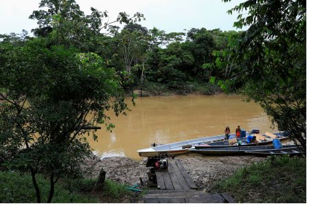 Indigenous Waorani people, whose territory is the subject of a referendum vote that may ban oil production in their region, stand on their boat at a dock in the Bameno community, in the Pastaza province, in Ecuador, July 29, 2023. REUTERS/Karen Toro