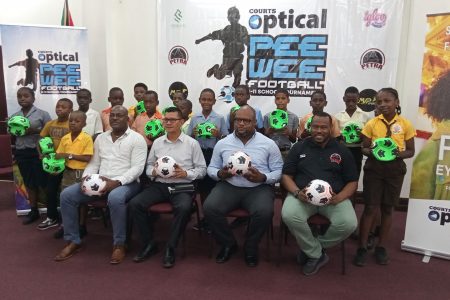Co-Director of the Petra Organization Troy Mendonca (sitting 1st from right), Richard Simpson, Courts Optical Chain Manager (2nd from right), Marti De Souza, Deputy Chief Education Officer (Hinterland) (3rd from right), and Deputy Director of Sports Franklin Wilson pose with representatives of the competing schools following the end of the ball distribution exercise yesterday