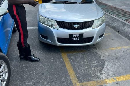 Yesterday, between 9 am and midday, ranks from the Guyana Police Force’s Traffic Headquarters conducted an enforcement exercise against motor vehicles parked dangerously and causing obstruction on streets in and around Georgetown. Several vehicles were ‘clamped’ using wheel clamps and eight tickets were issued for leaving a motor vehicle in a dangerous position. Sergeant Dowlin led the enforcement exercise. This police photo shows a vehicle about to be `clamped’.
