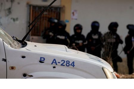 Police officers stand guard near a bullet-riddled police car at a crime scene where colleagues were killed in response to prisoner transfers from overcrowded prisons, prompting President Guillermo Lasso to declare a state of emergency in two provinces, in Guayaquil, Ecuador November 1, 2022. REUTERS/Santiago Arcos/File Photo 