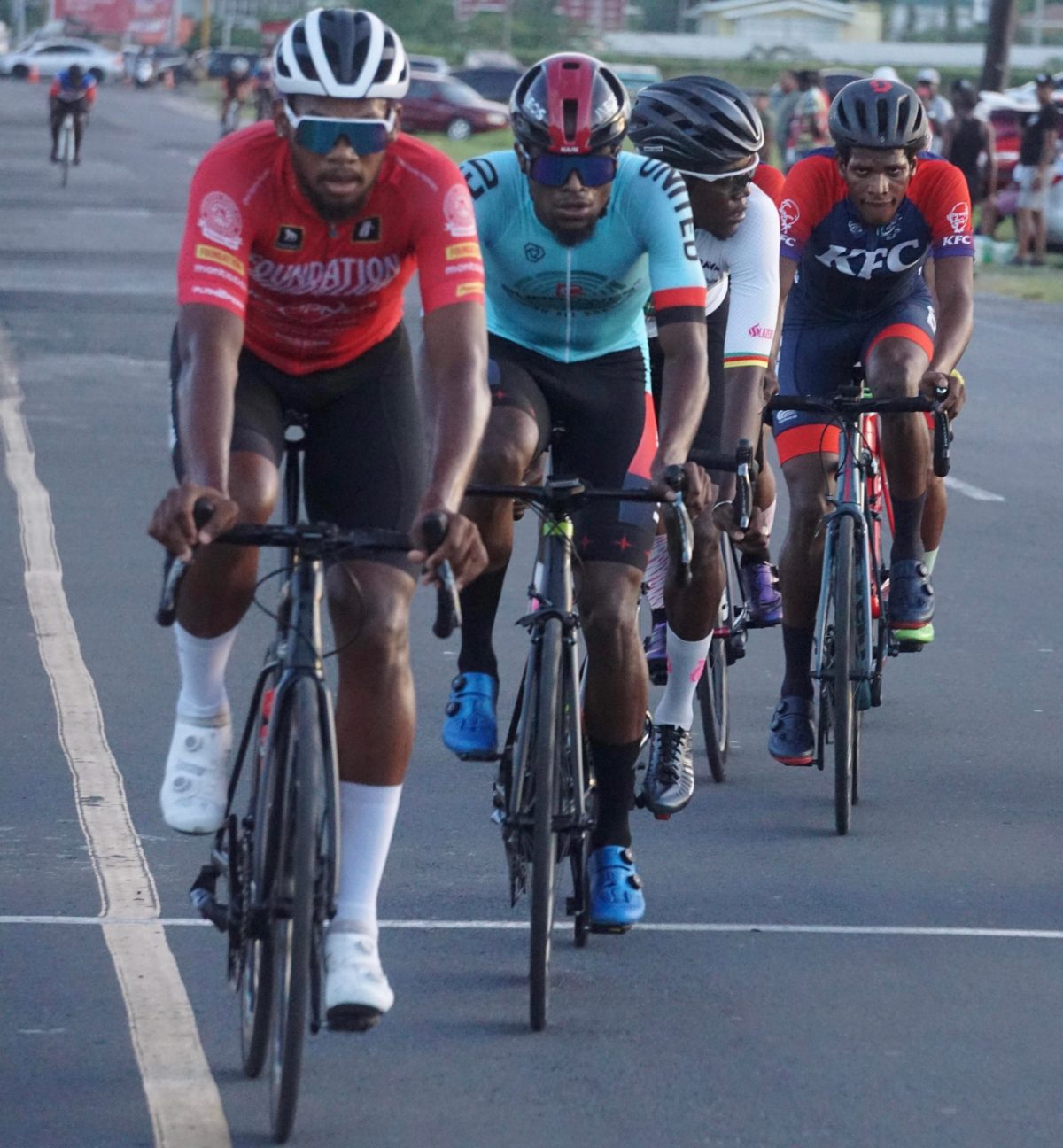 Star cyclist, Jamual John (left) of Team Foundation brought his talents back to Guyana and rode off with the spoils of the Team Alanis sponsored 50-mile road race yesterday. He led Curtis Dey (right) and Briton John (second from left) onto the podium. (Emmerson Campbell photo)