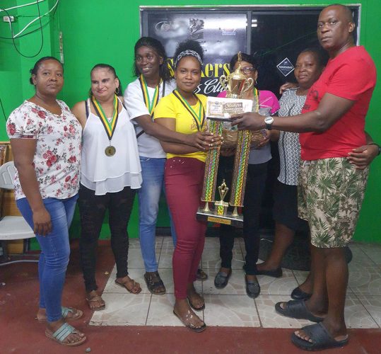 Handing over the winning trophy and cash prizes to the captain Tandica Adams of 1966 LAW surrounded by her jubilant charges is organizer Roderick Harry.
