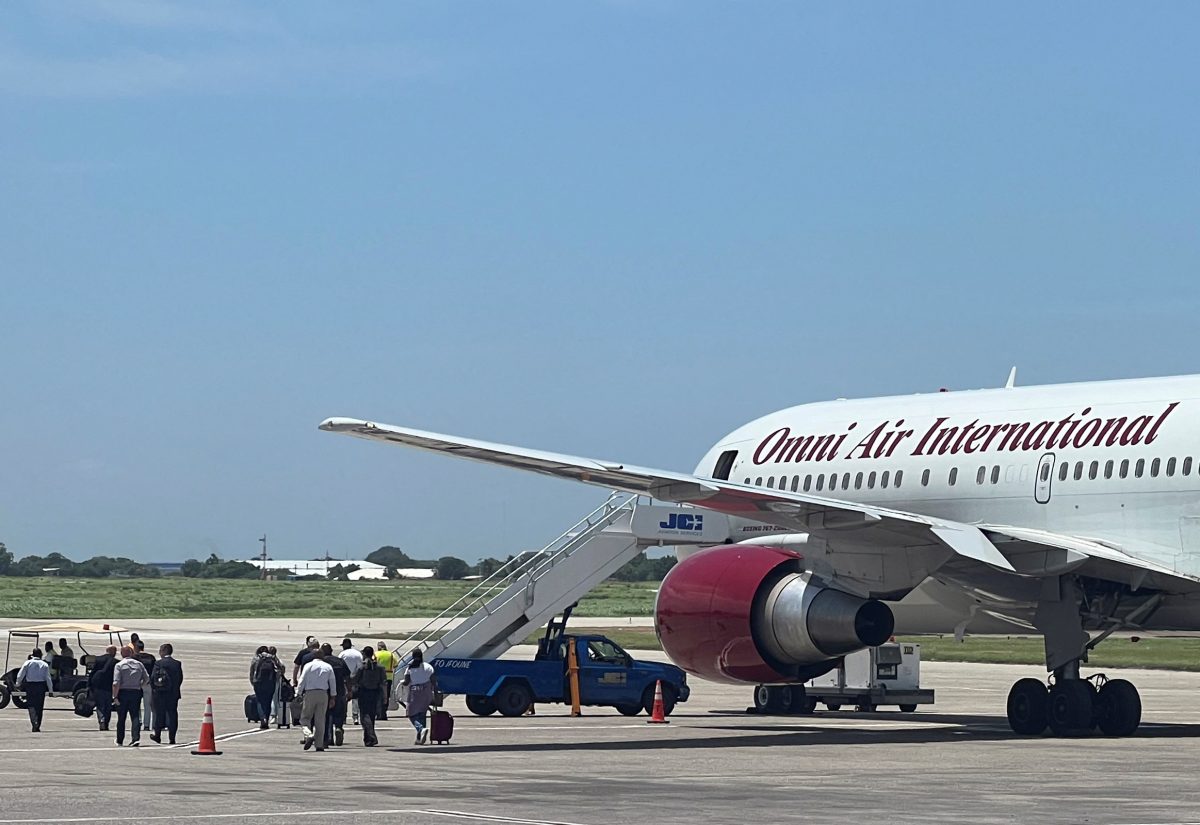 People, who had arrived in cars from the U.S. diplomatic mission, walk towards a Boeing 767 plane operated by U.S. charter airline Omni Air International, headed to the U.S., in Port-au-Prince, Haiti August 31, 2023. REUTERS/Ralph Tedy Erol