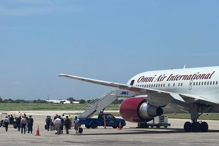 People, who had arrived in cars from the U.S. diplomatic mission, walk towards a Boeing 767 plane operated by U.S. charter airline Omni Air International, headed to the U.S., in Port-au-Prince, Haiti August 31, 2023. REUTERS/Ralph Tedy Erol